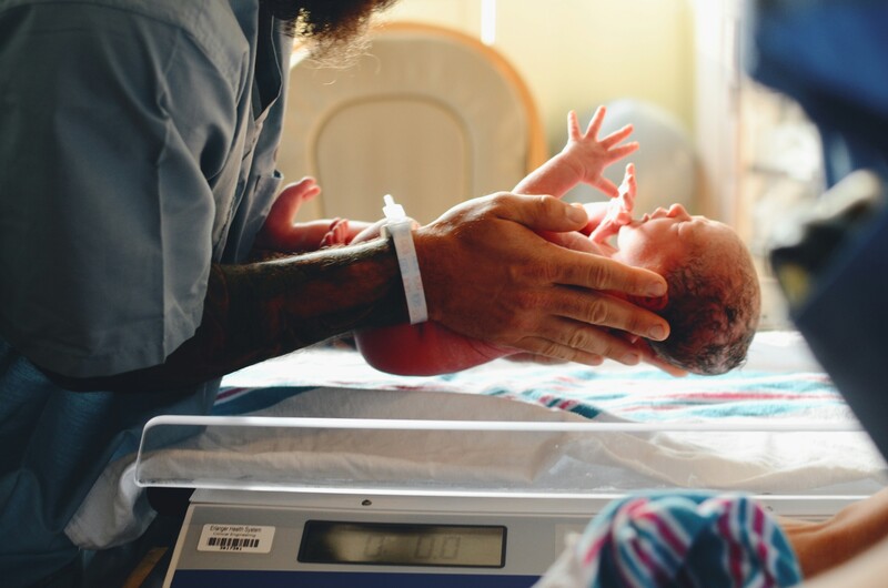 Nieuwgeboren baby wordt gewogen