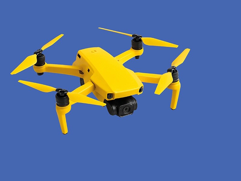 Gele drone tegen blauwe achtergrond