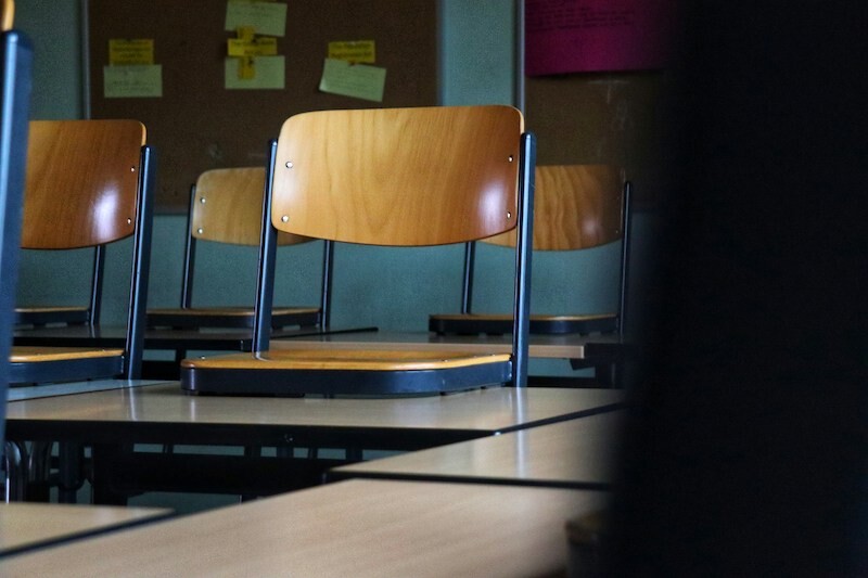 Schoolstoelen gestapeld op schoolbanken