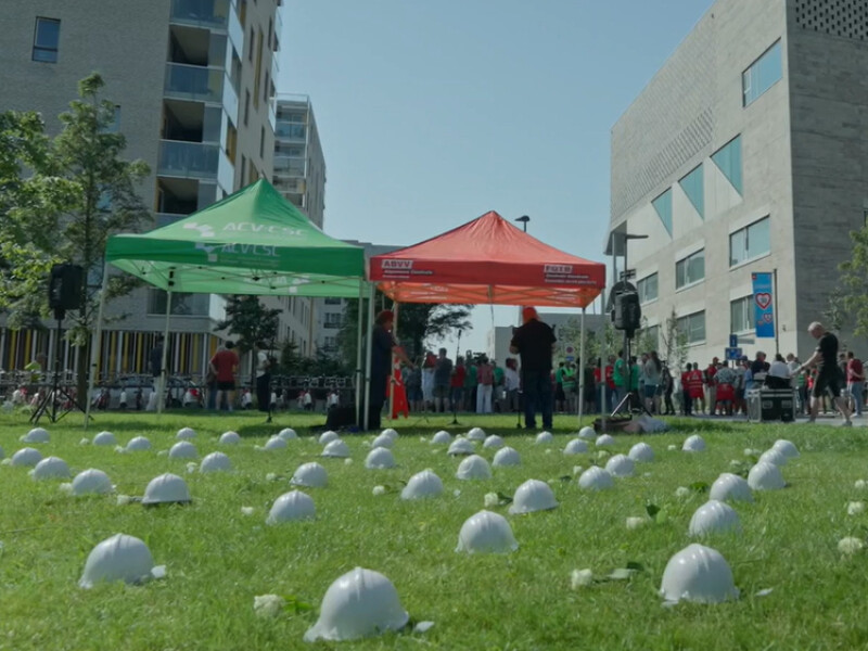 Witte helmen op grasveld als herdenking voor gesneuvelde bouwvakkers