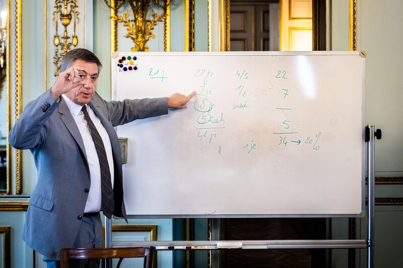 Minister van Financiën en Pensioenen Jan Jambon (N-VA) wijst naar een bord