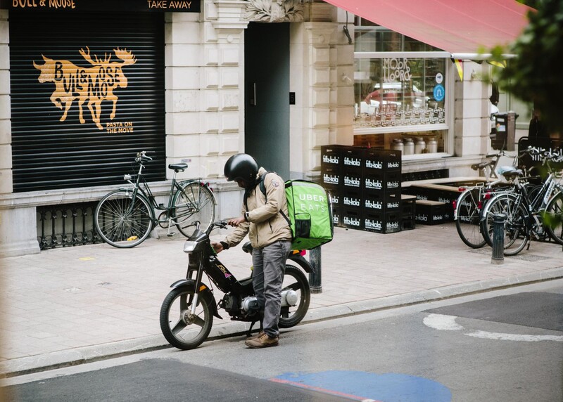 Koerier van Uber Eats met brommer