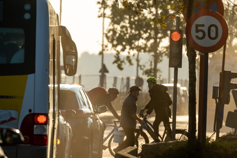 Druk kruispunt met fietsers, auto's en bus