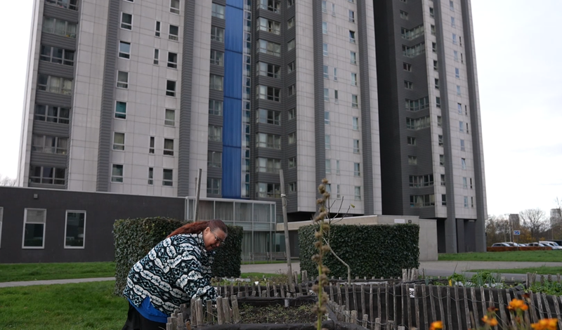 Vrouw is aan het werk in plantenbak voor woontoren
