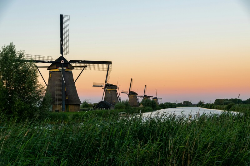 Windmolens aan een kanaal tegen zonsopgang